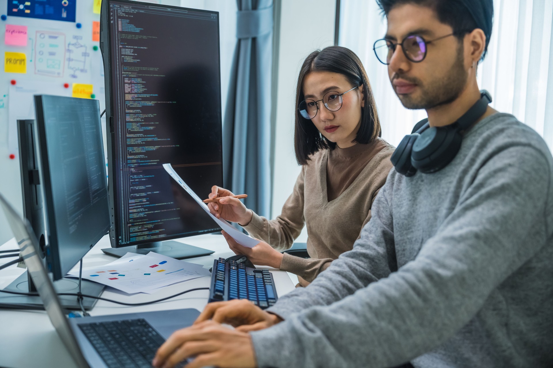 asian and Indian Developer team discussion feedback analysis coding data with software computer at office
